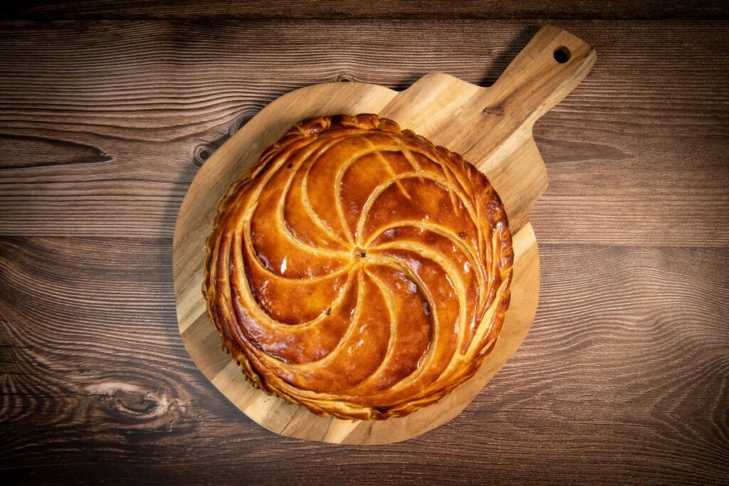 galette des rois on wooden table, traditional epiphany cake in france